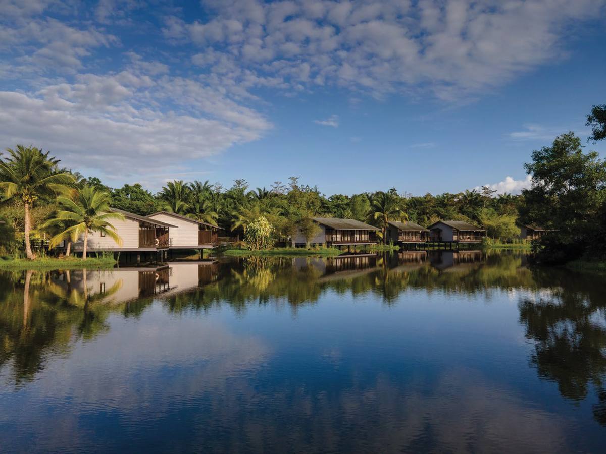 Mangala Resort & Spa chalets reflected on the lake
